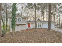 Charming two-story home featuring a neutral color scheme, red front door, and an attached two-car garage at 2436 Wilshire Ct, Decatur, GA 30035