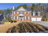 Charming two-story brick home with attached two-car garage, black shutters and a well-manicured front yard at 642 Towering Pine Trl, Lawrenceville, GA 30043