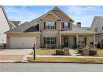 Charming two-story home with a manicured front yard, inviting porch, and attached two-car garage at 644 Crystal Cove Ct, Loganville, GA 30052