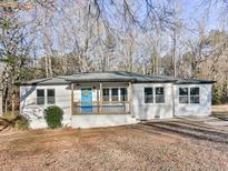 Charming ranch-style home featuring a covered front porch with a bright blue front door at 5205 Silhouette Sw Ln, Mableton, GA 30126
