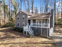 Charming gray home featuring a welcoming front porch and well-maintained landscaping surrounded by mature trees at 603 Savannah Way, Woodstock, GA 30189