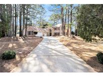 Charming brick home with a long driveway, lush trees, and a three car garage at 11 Tallulah Ct, Jonesboro, GA 30236