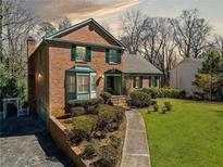 Charming brick home featuring manicured landscaping, bay window, and a welcoming walkway leading to the front door at 301 Millbrook Farm Ct, Marietta, GA 30068
