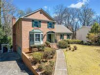 Charming two-story brick home with a well-manicured lawn, mature trees, and a welcoming walkway at 301 Millbrook Farm Ct, Marietta, GA 30068