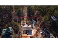 Aerial view of the property, surrounded by lush trees, featuring a detached garage, driveway, and well-maintained lawn at 326 Bethel Dr, Woodstock, GA 30189