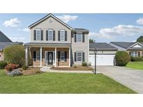 Charming two-story home with a well-manicured lawn, attached garage, and welcoming front porch at 2311 Fall Creek Lndg, Loganville, GA 30052