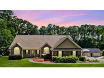 Inviting single-story home with stone accents, manicured lawn, and attached garage at 2517 N Hightower Trl, Conyers, GA 30012