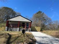 Charming home with a concrete driveway, mailbox, and a well-manicured yard under a clear blue sky at 624 S Grand Nw Ave, Atlanta, GA 30318