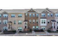 Attractive multi-story brick townhomes with manicured landscaping, and wrought iron railing at 656 Sunset Park Dr, Suwanee, GA 30024