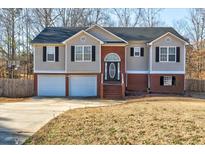 Charming split-level home featuring a two-car garage, brick accents, and an inviting front entrance at 75 Aspen Dr, Covington, GA 30016