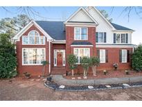 Charming two-story brick home featuring a manicured front yard, and a welcoming entrance, and a symmetrical design at 2118 Sableshire Se Way, Conyers, GA 30013
