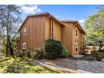 Charming two-story home with a vertical wood plank exterior and a lush green lawn at 838 Lake Hollow Sw Blvd, Marietta, GA 30064