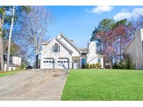 Charming two-story home with a two-car garage and a well-manicured front lawn at 740 Helga Ne Dr, Woodstock, GA 30188