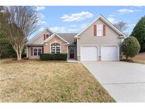 Charming single-Gathering home with neutral siding, stone accents, an attached two-car garage, and a well-manicured front lawn at 2405 Landrum Ct, Lawrenceville, GA 30043