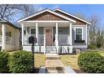 Charming home exterior with covered porch, gray siding, and a beautifully landscaped front yard at 1057 Fortress Sw Ave, Atlanta, GA 30315