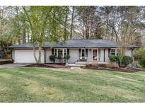 Charming single-story home with a brick facade, well-maintained lawn, and mature trees offering shade at 2031 Audubon Ne Dr, Atlanta, GA 30329