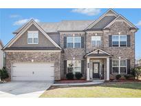 Charming two-story brick home with a well-maintained front yard and a two-car garage at 4225 Sharpton Park Dr, Auburn, GA 30011