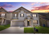 Two-story home featuring a gray brick exterior, a two-car garage and a well manicured front yard at 7554 Crawford Ct, Fairburn, GA 30213