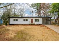 Charming one-story home with a red door, fresh white siding, and well-manicured yard at 1506 Sycamore Nw Dr, Kennesaw, GA 30152