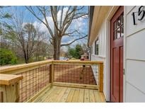 Charming home featuring a newly constructed wood porch and a classic red front door at 1506 Sycamore Nw Dr, Kennesaw, GA 30152