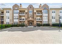 Brick condo building with balconies, manicured landscaping, and plenty of parking at 220 Renaissance Ne Pkwy # 1205, Atlanta, GA 30308