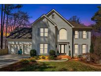 Charming two-story home with a three-car garage, beautiful landscaping, and a brick facade at 2447 Elmhurst Nw Blvd, Kennesaw, GA 30152