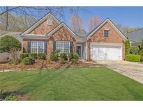 Charming brick home with a well-manicured lawn, beautiful landscaping, and an attached two-car garage at 6560 Waveland Dr, Cumming, GA 30040
