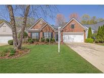 Charming brick home with well-manicured lawn and landscaping at 6560 Waveland Dr, Cumming, GA 30040