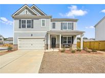 Charming two-story home featuring a welcoming front porch and a well-manicured lawn on a sunny day at 288 Highgrove Way, Dallas, GA 30157