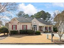 Charming brick home features red shutters, manicured lawn, and inviting front porch at 9620 Coastal Pointe Dr, Villa Rica, GA 30180