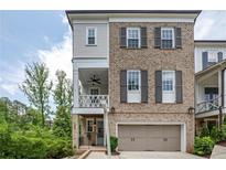 Charming two-story brick home featuring a covered porch and a two-car garage at 385 Rowes Cir, Alpharetta, GA 30009