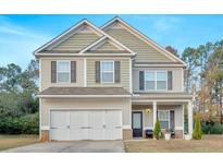 Charming two-story home with neutral siding, a two-car garage, and a well-manicured front lawn at 74 Macland Mill Ln, Dallas, GA 30157