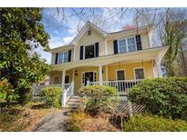 Charming two-story home featuring a welcoming front porch with white railing and well-maintained landscaping at 2141 Summerchase Dr, Woodstock, GA 30189