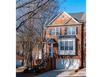 Charming brick townhome featuring a front-facing garage, black shutters, and inviting front entrance at 401 Iona Abbey Se Ct # 6, Smyrna, GA 30082