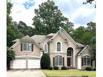 Charming two-story home with a well-manicured lawn and attached two-car garage at 4260 River Club Dr, Cumming, GA 30041