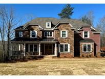 Charming two-story home with a combination of brick and stone exterior and a welcoming front porch at 7469 Waterview Cv, Douglasville, GA 30135