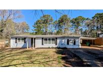 Charming single-story home featuring a brick facade, well-manicured lawn, and a convenient carport at 4214 Canby Ln, Decatur, GA 30035