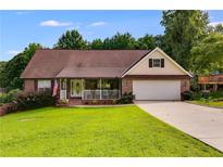 Charming brick home with a well-manicured lawn and a covered front porch with white railings at 144 Bobs Sw Dr, Mableton, GA 30126