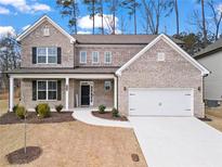 Charming two-story brick home with covered porch and attached two-car garage at 3479 Jasmine Sw Way, Atlanta, GA 30331