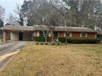 Charming brick home with a carport and manicured landscaping at 403 Colchester Dr, Stone Mountain, GA 30088