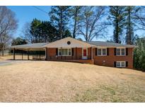 Charming brick home featuring a cozy carport and a well-manicured front lawn at 1276 Kingsview Se Cir, Smyrna, GA 30080
