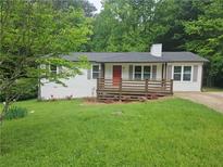 Charming home featuring a quaint front deck, white siding and a bright red door at 147 Mildred Ct, Dallas, GA 30157