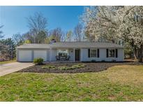Charming single-story home featuring a well-maintained lawn and inviting front porch with seating, with an attached two-car garage at 2814 Pine Meadow Dr, Marietta, GA 30066