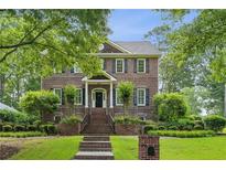 Beautiful two-story brick home with mature landscaping, manicured lawn, and inviting entryway at 2039 Fisher Ne Trl, Atlanta, GA 30345