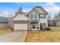 Charming two-story home featuring a well-manicured lawn, stone accents, and an attached two-car garage at 2534 Grayton Loop, Villa Rica, GA 30180