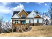 Charming two-story home with a welcoming front porch and stone accents, nestled on a lush green lawn at 64 Roberson Ne Dr, Cartersville, GA 30121