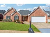Charming single-story brick home featuring an attached two-car garage, well-manicured lawn, and a welcoming entryway at 219 Prominent Loop, Mcdonough, GA 30253