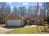 Charming single-story home with stone accents, a two-car garage, and well-manicured lawn at 145 Alcovy Cir, Covington, GA 30014