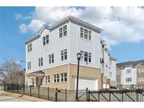 Beautiful three-story home featuring light blue siding, white trim, and a brick base with an attached garage at 2000 Ocean Nw Dr, Atlanta, GA 30318