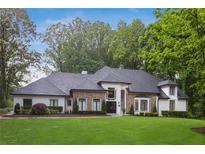 Stunning home featuring a manicured lawn, stone accents, black framed windows, and a charcoal-colored roof at 1460 Lakemist Ct, Roswell, GA 30075